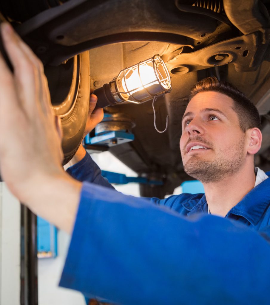 Mechanic under a vehicle - Car & Bike MOT Testing in Bedford